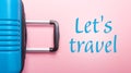 Words Let`s Travel Blue suitcase on pastel pink background Creative Summer holidays, vacation, travel concept Banner Royalty Free Stock Photo