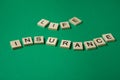 Words life insurance by wooden blocks on green background. Royalty Free Stock Photo