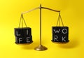 Words Life, Work made with black cubes on scales against yellow background. Balance concept Royalty Free Stock Photo