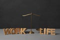 Words Life and Work made of wooden letters near scales on grey table. Balance concept Royalty Free Stock Photo