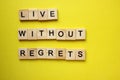 The words Live without regrets on a yellow background. Motivation banner. Royalty Free Stock Photo