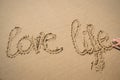 The words love life written in the sand