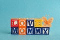 The words love mommy spelled with alphabet blocks