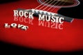Words Love Rock Music with wooden letters, on reflecting surface of an acoustic guitar. Guitars bridge perspective. Creative