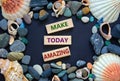 Words `make today amazing` on wooden blocks on a beautiful black background. Sea stones and seashells. Inspirational motivationa