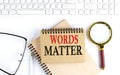 WORDS MATTER text in office notebook with keyboard, magnifier and glasses , business concept Royalty Free Stock Photo