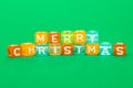 words merry christmas made of colorful blocks on green background. Flat lay, top view - holidays, winter, christmas and new year c Royalty Free Stock Photo