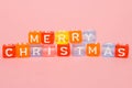 words merry christmas made of colorful blocks on pink background. Flat lay, top view - holidays, winter, christmas and new year ce Royalty Free Stock Photo