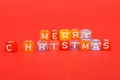 words merry christmas made of colorful blocks on red background. Flat lay, top view - holidays, winter, christmas and new year cel Royalty Free Stock Photo