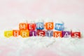 words merry christmas made of colorful letters blocks on white snow background. Flat lay, top view - holidays, winter, christmas a Royalty Free Stock Photo