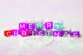 words merry christmas made of colorful letters blocks on white snow background. Flat lay, top view - holidays, winter, christmas a Royalty Free Stock Photo