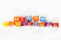 words merry christmas made of colorful letters blocks on white snow background. Flat lay, top view - holidays, winter, christmas a Royalty Free Stock Photo