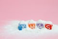 words merry christmas made of colorful letters blocks on white snow and pink background. Flat lay, top view - holidays, winter, ch Royalty Free Stock Photo