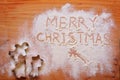 Words `Merry Christmas` written in spread flour and a variety of cookie cutters on a wooden chopboard Royalty Free Stock Photo