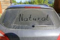 Words NATURE on the dusty, dirty windscreen of a car