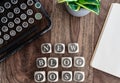 Words NEW BLOG POST on wooden blocks on table with note pad, potted plant and vintage typewriter Royalty Free Stock Photo