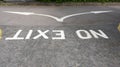 No Exit painted white onto the road and viewed upside down with a split arrow indicating alternative directions