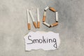 Words No Smoking made with cigarettes and paper on grey table, flat lay Royalty Free Stock Photo