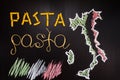 Words pasta made of cooked spaghetti and dry pasta on the black background with frame of country Italy written by chalk Royalty Free Stock Photo