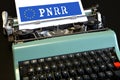 words \'PNRR\' typed on vintage typewriter with European flag.