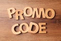 Words Promo Code made of wooden letters on table, flat lay