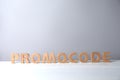 Words Promo Code made of wooden letters on white table, space for text