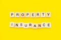 Words property insurance. Wooden blocks with lettering on top of yellow background. insurance concepts