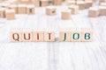 The Words Quit Job Formed By Wooden Blocks On A White Table, Reminder Concept