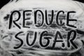 Words Reduce Sugar written in and with sugar grains, capital let