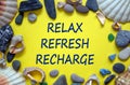 Words `relax, refresh, recharge` on a beautiful yellow background. Sea stones and seashells. Concept