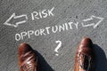 Words Risk, Opportunity and arrows on the ground in front of a man's shoes Royalty Free Stock Photo