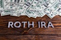 Words ROTH IRA laid on wooden surface by metal letters with us dollar banknotes Royalty Free Stock Photo