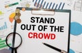 The words Stand out of the crowd written on a white notebook Royalty Free Stock Photo