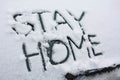 Words Stay Home on snowy back of car