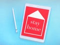 The words stay home on the tablet screen, the concept of quarantine at home as a preventive measure against the spread of