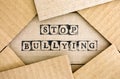 Words Stop Bullying make by black alphabet stamps on cardboard