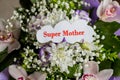 The words Super Mom written in a white paper shit isolated floral background. Concept of love for mother`s.flowers Royalty Free Stock Photo