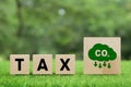 Words TAX on a wooden cube with co2 icon. Carbon tax, CO2 tax, environmental and social responsibility business concept. Taxation