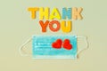 Words THANK YOU of wooden letters and face protection mask