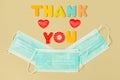 Words THANK YOU of wooden letters and face protection masks in smile shape