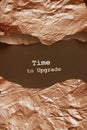 The words Time To Upgrate.appearing behind torn bronze foil. Business concept for updating something Royalty Free Stock Photo