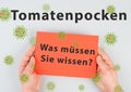 The words tomato pox, what you need to know, are standing in german language on a paper, outbreak of the virus in India