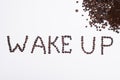 Words wake up from coffee beans isolated on white background