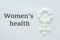 Words Women`s Health and female symbol made of pills on white background, flat lay