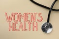 Words Women`s Health and stethoscope on beige background, top view
