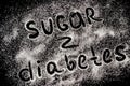 words Sugar - Diabetes; on a scattering of sugar crystals, blac