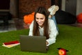 Work anywhere concept. Smile girl on green carpet Royalty Free Stock Photo