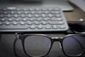 Work area with keyboard and eye glasses Royalty Free Stock Photo