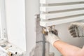 Work As A Plumber, mounting water heating radiator on the white wall indoors. connection heating pipes to white Radiator Royalty Free Stock Photo
