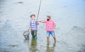 Work as a team. rural getaway. hobby. wild nature. two happy fisherman with fishing rod and net. Camping on the shore of